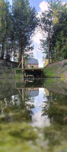 a house on a bridge over a body of water at Agroturystyka Kryjówka Nad Stawem in Kodeń