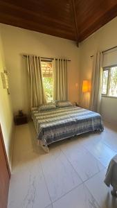 a bedroom with a bed and a large window at A Casa da lua in Lagoa Santa