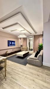 a living room with a couch and a tv at Leria Living luxury 2 bedroom wuye, Abuja in Ankuru