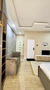 a living room with a couch and a bed at Leria Living luxury 2 bedroom wuye, Abuja in Ankuru