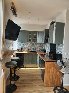 a kitchen with green cabinets and a counter top at Le coeur de Mers in Mers-les-Bains