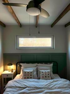 a bedroom with a bed with a green headboard and a window at POLANKA - Krzynki 16A in Krzynki +8 photos