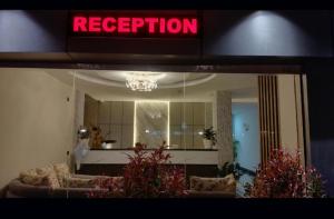 a reflection of a living room with a red neon sign at Hotel Delw in Bacha