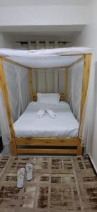 a bed with two slippers on top of it at Chateau Haven in Kakamega