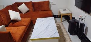 a living room with a brown couch and a table at Chateau Haven in Kakamega