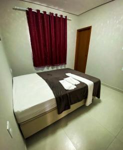 a bedroom with a bed with a red curtain at Espaço Sonhos da Serra in Bananeiras