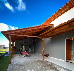a patio with a wooden pergola with a table and chairs at Espaço Sonhos da Serra in Bananeiras