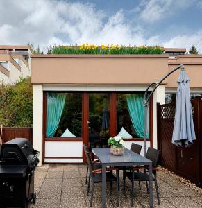 a patio with a table and chairs and a building at Wald Living in Baiersbronn