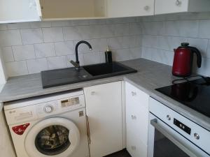 a kitchen with a washing machine and a sink at Pärnade Apartment in Paikuse
