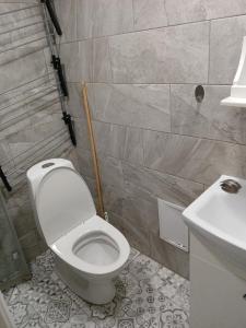 a bathroom with a white toilet and a sink at Pärnade Apartment in Paikuse