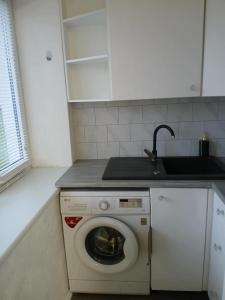a kitchen with a washing machine and a sink at Pärnade Apartment in Paikuse