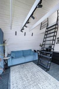 a blue couch in a living room with a ladder at A-frame cottage in Mykulychyn