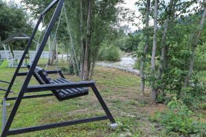 a swing in a yard next to trees at A-frame cottage in Mykulychyn +26 photos