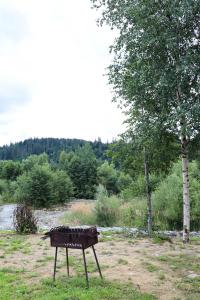 a barbecue grill sitting in the middle of a field at A-frame cottage in Mykulychyn