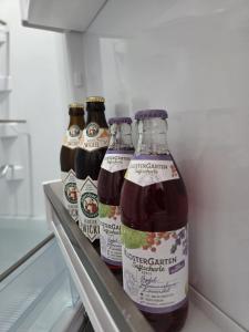 three bottles of beer sitting on a shelf in a refrigerator at Calm Sun Apartment in Alpirsbach