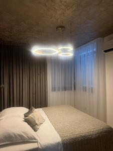 a bedroom with a bed and a chandelier at Apartmán Maťko in Levice +7 photos