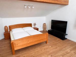 a bedroom with a bed and a flat screen tv at Apartment am Starnberger See in Tutzing