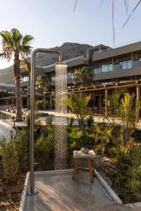 a water fountain in front of a building with a bench at Pefkian Ethos Hotel & Suites in Pefki