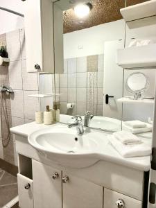 a white bathroom with a sink and a mirror at Apartma Olive & Spice in Koper +39 photos