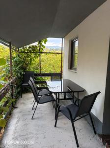 a patio with a table and chairs and a window at Apartma TI & JAZ in Vrh