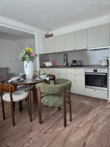 a kitchen with a table and chairs and a vase of flowers at Calm Sun Apartment in Alpirsbach