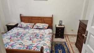 a bedroom with a bed and two night stands at Location salamandre in Mostaganem
