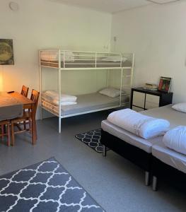 a room with two beds and a table and a desk at Torsby Vandrarhem in Torsby +112 photos