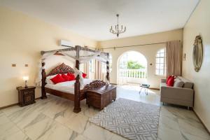 a bedroom with a canopy bed and a couch at White Hill Penthouse in Kisumu
