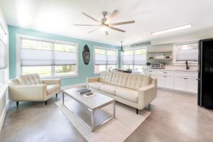 a living room with two couches and a ceiling fan at Coastal Escape for 2 - Pool, Fire Pit & Beach Access in Saint Simons Island