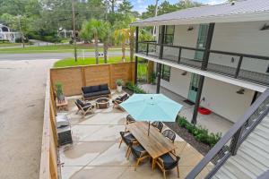 a patio with a table and chairs and an umbrella at Coastal Escape for 2 - Pool, Fire Pit & Beach Access in Saint Simons Island