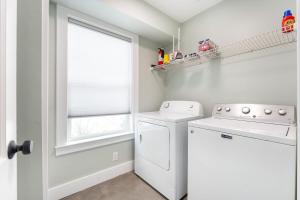 a laundry room with a washer and dryer and a window at Coastal Escape for 2 - Pool, Fire Pit & Beach Access in Saint Simons Island