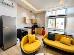 a kitchen with a yellow couch and a refrigerator at Appartement à Cotonou in Cotonou