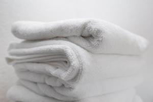 a white towel sitting on top of a bed at Central Jylland Suite in Aalborg +28 photos