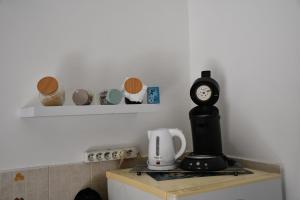 a kitchen with a coffee maker and a clock on a counter at VILLA CREOLE in Gourbeyre