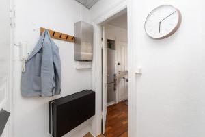 a clock hanging on a wall next to a hallway at Central Jylland Suite in Aalborg