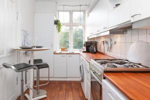 a kitchen with white cabinets and a stove top oven at Central Jylland Suite in Aalborg