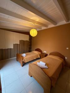 a hotel room with two beds and a light fixture at JORGO in Kremasti