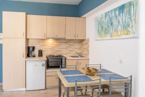 eine Küche mit Tisch, Stühlen und Kühlschrank in der Unterkunft Sami View Studios in Sami