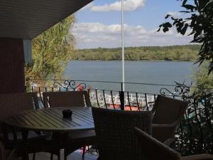 a table and chairs on a balcony with a view of a lake at Vila VERA in Mahmudia