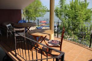 a balcony with a table and chairs and a view of the water at Vila VERA in Mahmudia