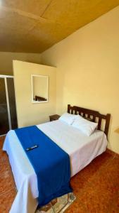 a bedroom with a large bed with a blue blanket at Accommodation #7 in Copán Ruinas