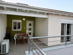 a balcony with a table and a dining room at JORGO in Kremasti