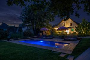 a swimming pool in the yard at night at La Mare aux Oiseaux, The Originals Collection in Saint-Joachim