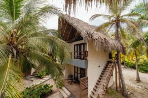 ein Haus mit Strohdach und Palmen in der Unterkunft Tay Beach Hotel Tayrona in Buritaca + 50 Fotos