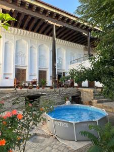 a large swimming pool in a yard with a building at Merik Boutique in Bukhara