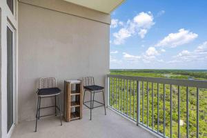 a balcony with two chairs and a view of the ocean at Top-Floor Studio with Ocean Views and Pool in Destin