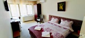 a bedroom with a bed with a red and white blanket at Cazare Casa Sandra in Băile Herculane