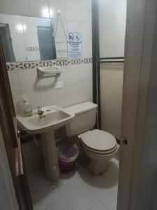 a small bathroom with a toilet and a sink at Continental Aparta Hotel Duitama in Duitama +26 photos