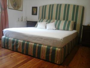 a bed with a striped headboard with two pillows on it at Bio&B Cascina Montebello in Palazzago
