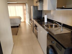 a kitchen with a sink and a counter top at Otgreen suites in Gaborone